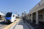 An early afternoon westbound coming into Redlands-Downtown Station with the former Santa Fe RR Redlands Depot building on the right 